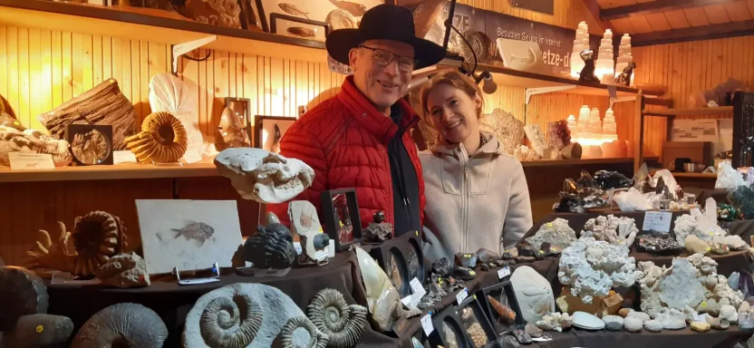 Weihnachtsmarkt in Esslingen: Zwei Personen präsentieren ein Fossil vor Verkaufsständen mit Ammoniten, Kristalle, Kristallen und Mineralien.